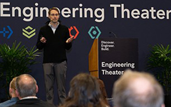 Attendees listen to the speaker on the Engineering Theater stage