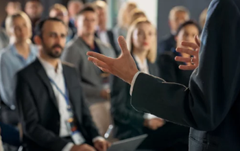 A man presenting to an audience, engaging with the group