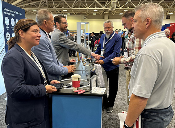 Attendees speak to exhibitors at a booth in MD&M Midwest