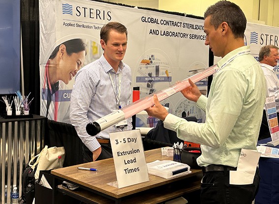 Attendee examines product while exhibitor looks on