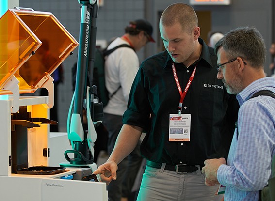 Exhibitor demonstrates a piece of equipment to an attendee
